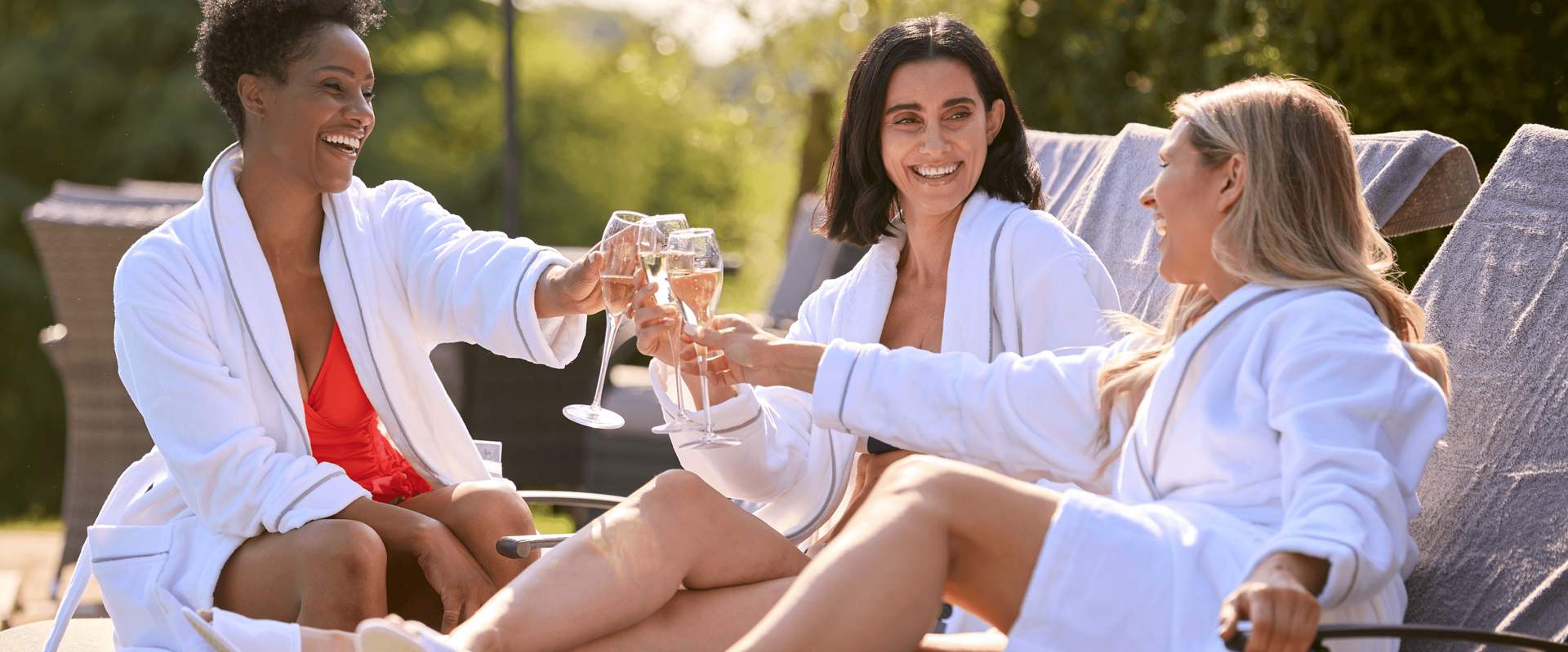 Three laughing women with a glass of wine